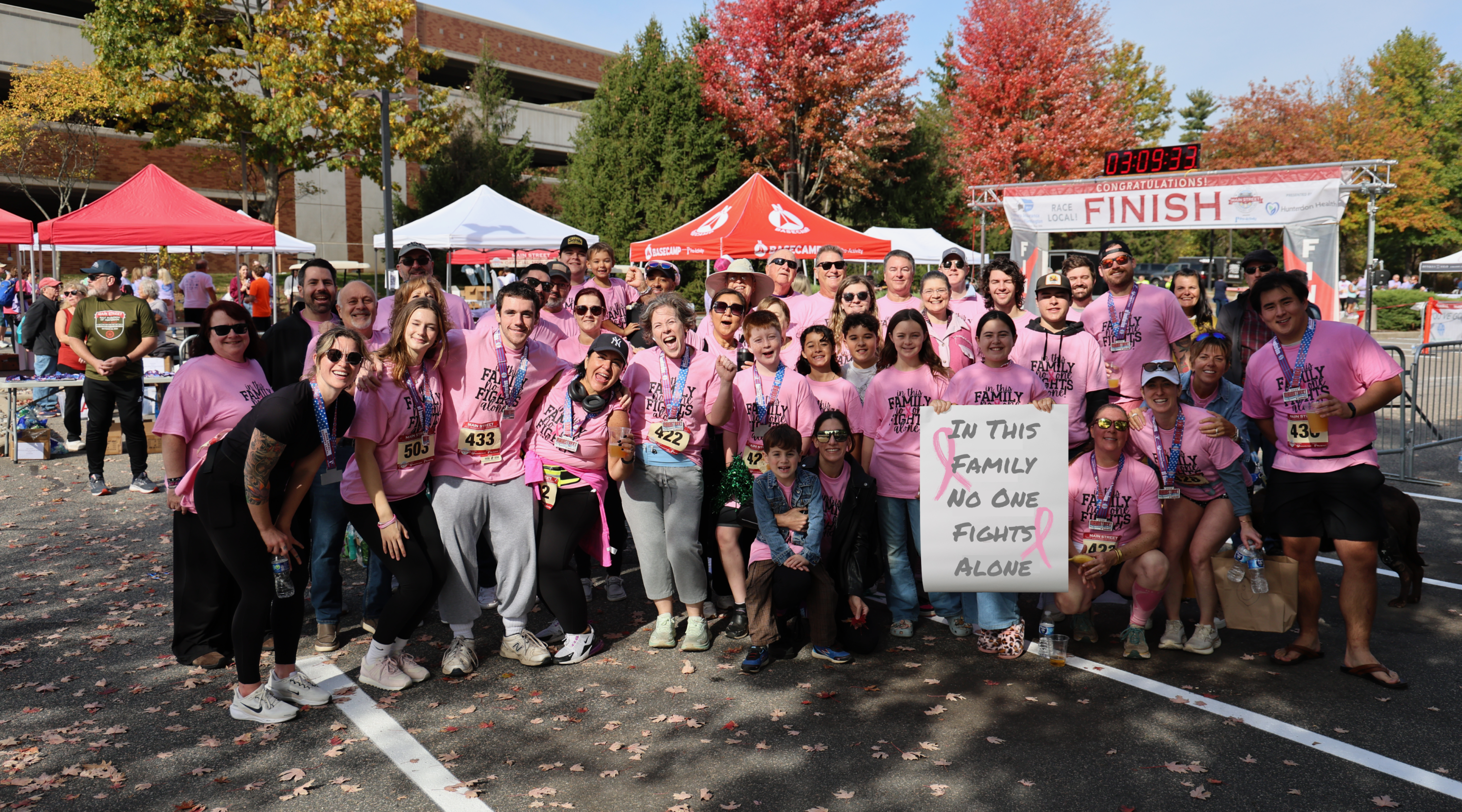 Race team poses in front of finish line