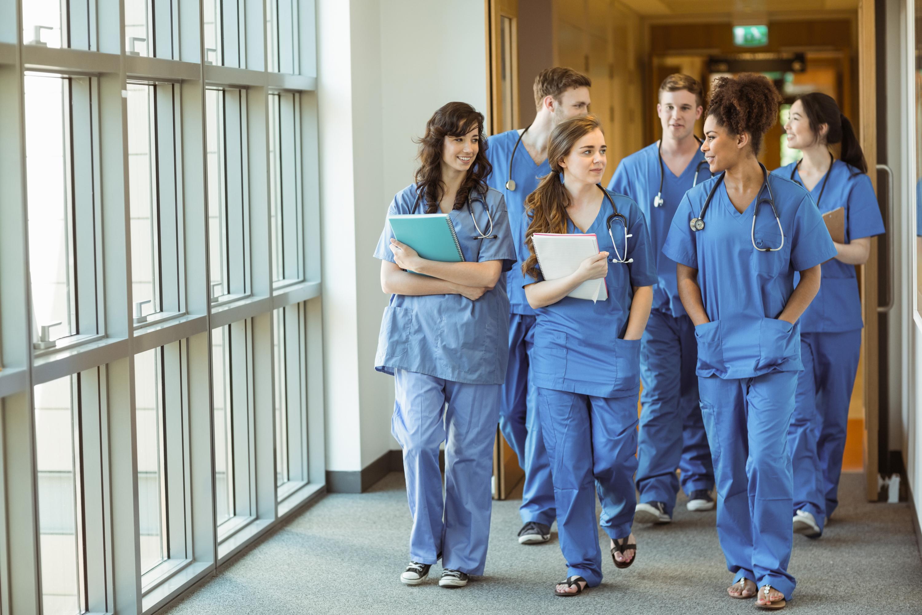 Students in scrubs in hospital hallway
