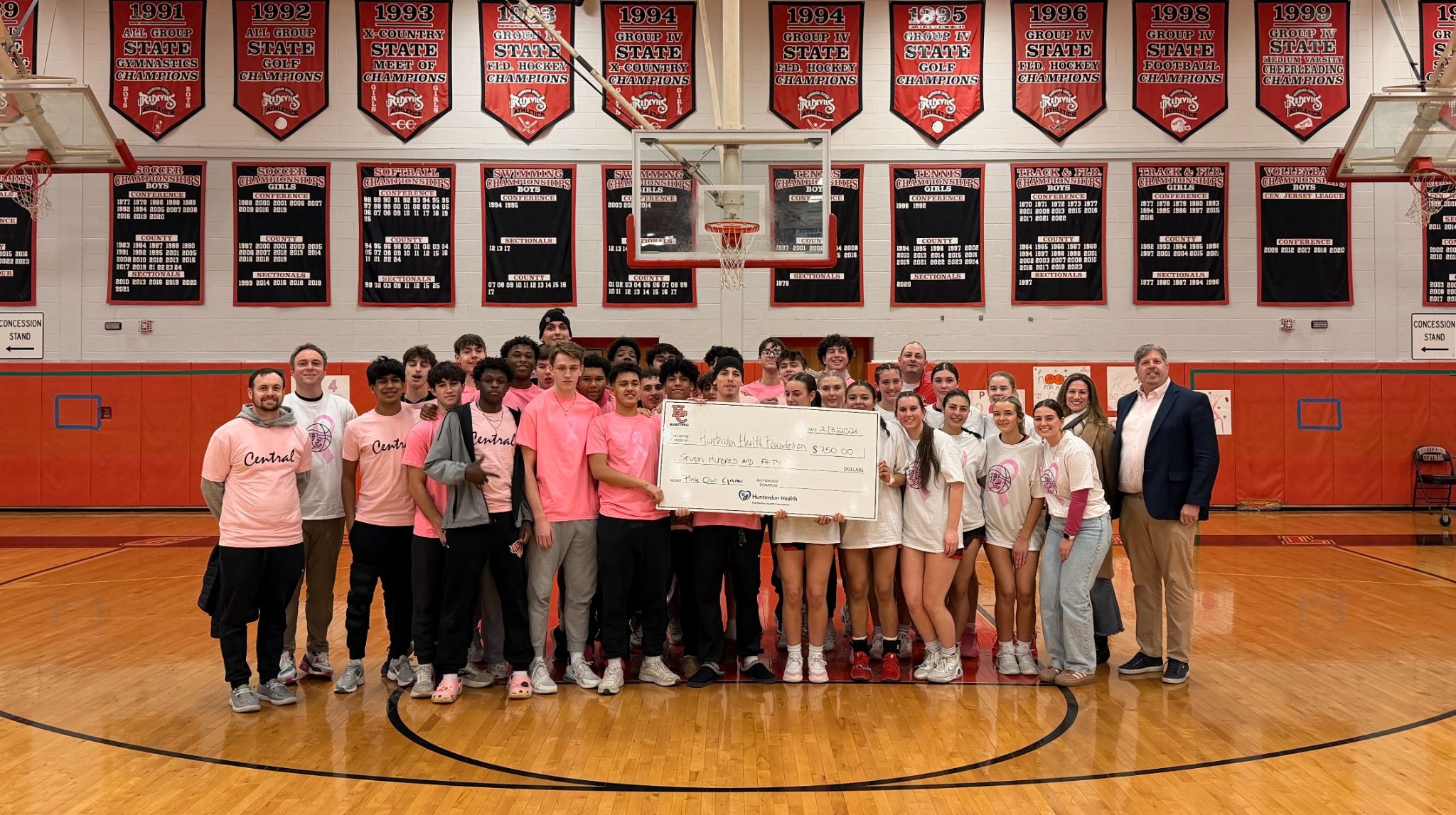 Hunterdon Central boys' and girls' basketball teams present check to Hunterdon Regional Cancer Center at Pink Out game