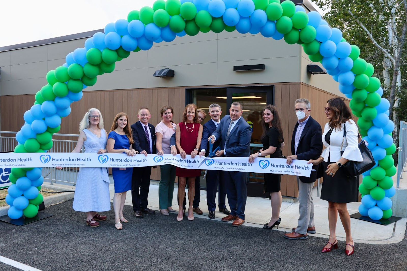 Hunterdon Health Physicians, Administrators, Board Members, and Donors cut ribbon in front of new Dr. Laurence M. Russell, Jr. Campus at Phillips-Barber