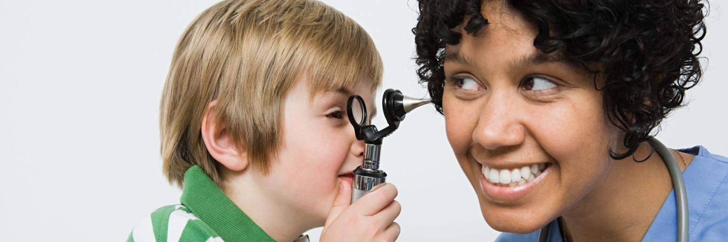 Child checking doctors ear during well visit to make him at ease 