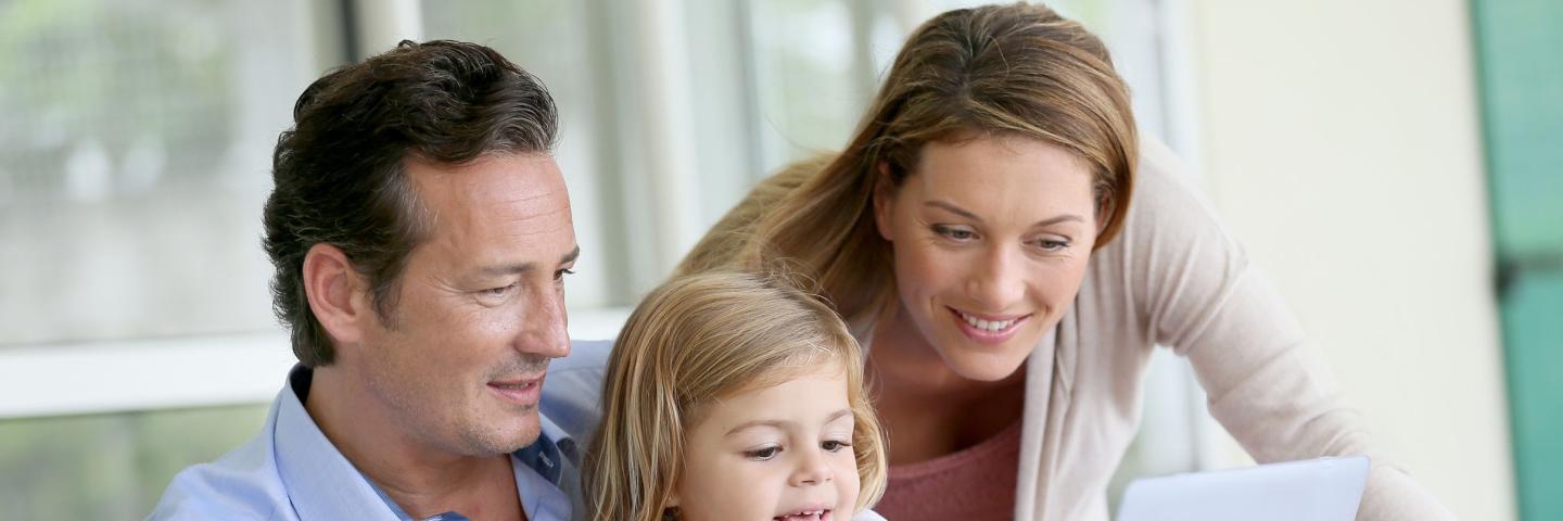 Parents and female child on a computer 