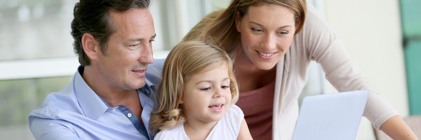 Parents and female child on a computer 