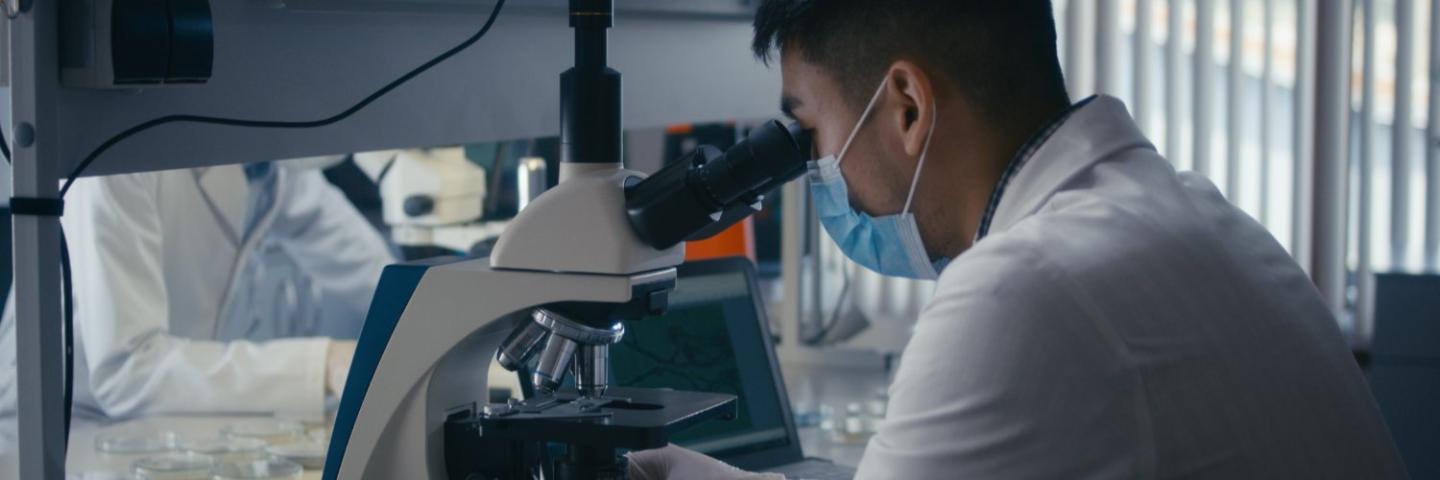 Lab Tech examining a sample under a microscope