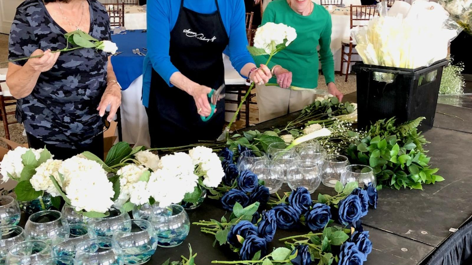 Foundation Auxiliary Members prep flower arrangements for an event