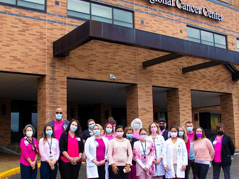 Employees gather for a breast cancer awareness photo dressed in pink.