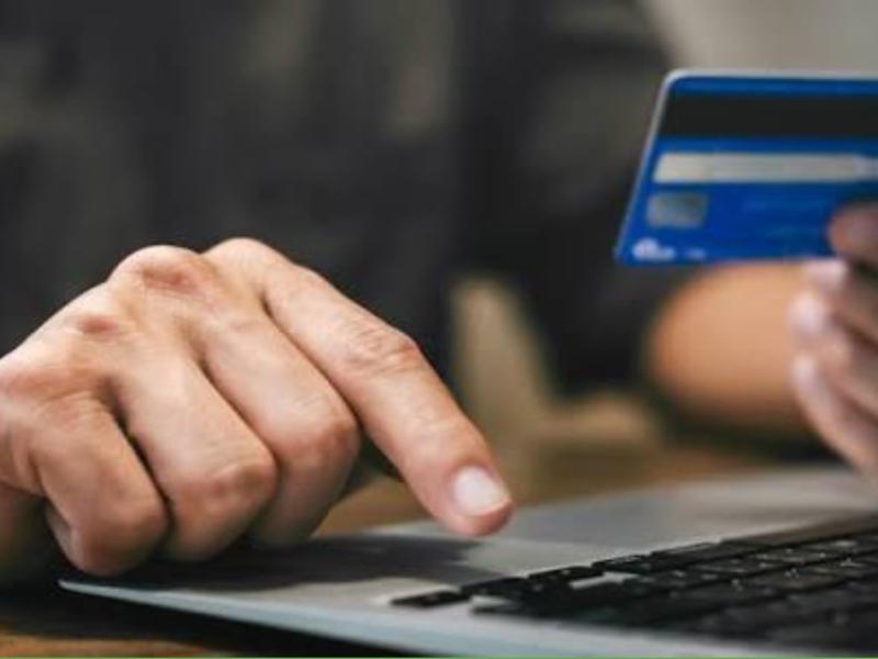 hands entering credit card info onto a laptop