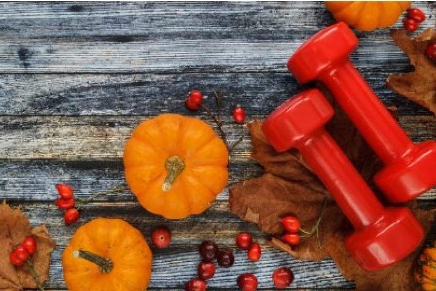 small pumpkins and red hand weights on fall scene