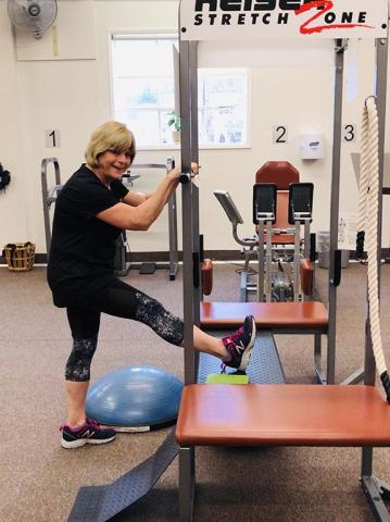Photo of member using squat rack to stretch