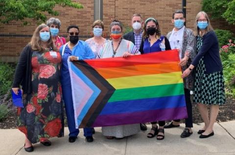 A group of employees holding the Pride flag.