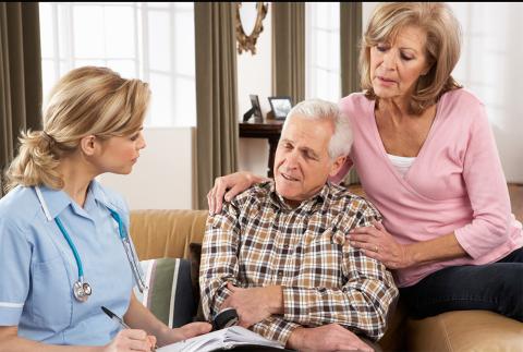 Male patient sitting with wife talking to the nurse