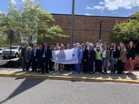 Hunterdon Health employees gather to raise the flag in support of Donate Life Month.