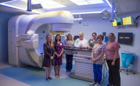 Employees pose around the new linear accelerator.