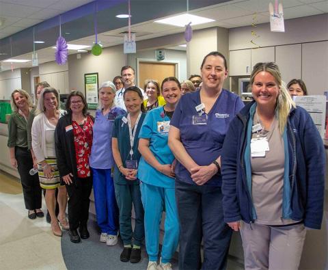 Group gathered around Maureen Moran Daisy Award winner.